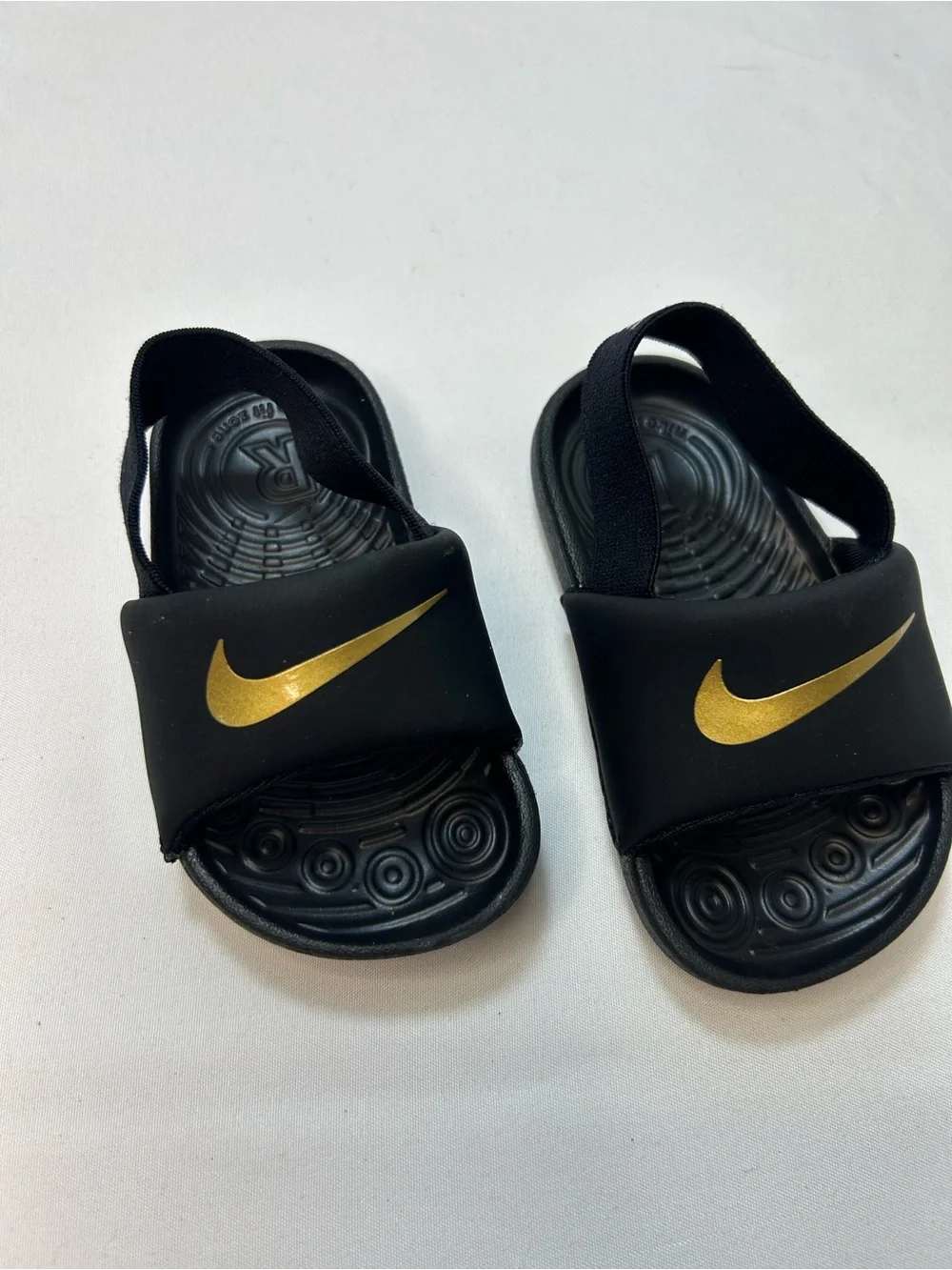 Nike Kids Black Slides with Gold Swoosh and Elastic Heel